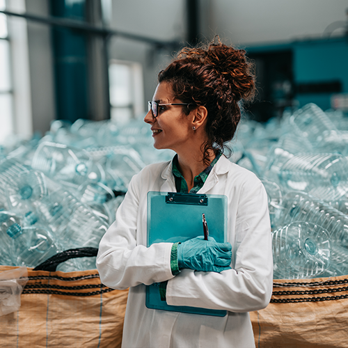 Woman holding blue clipboard in recycling room.